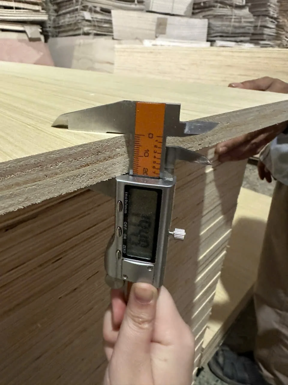 Thickness measurement caliper checking plywood at Mika Plywood QC station