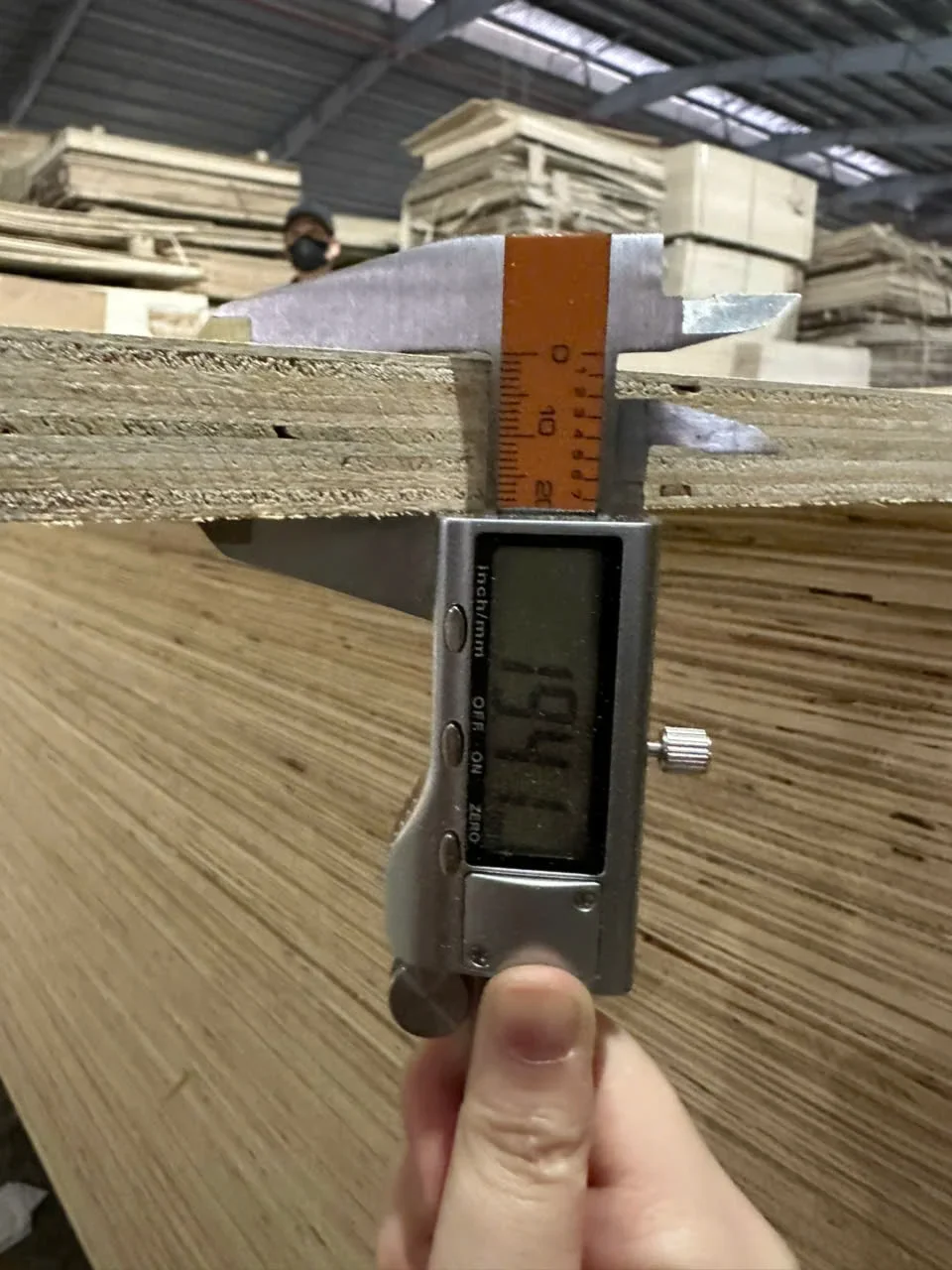 Plywood thickness measurement with caliper during QC inspection at Vietnam factory